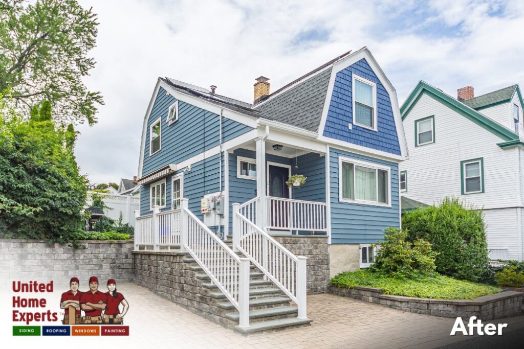 A charming blue house with new siding and crisp white trim, completed by United Home Experts in Ashland, MA