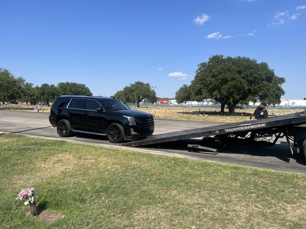 A blue pickup truck being loaded onto a flatbed tow truck by AB Towing & Transport in San Antonio, TX.