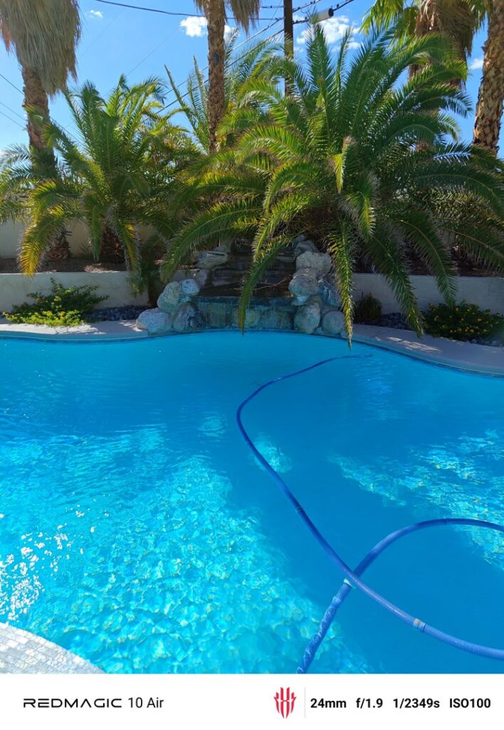 A blue pool vacuum hose visible in a swimming pool by Suburban Pool Company in Germantown, WI.