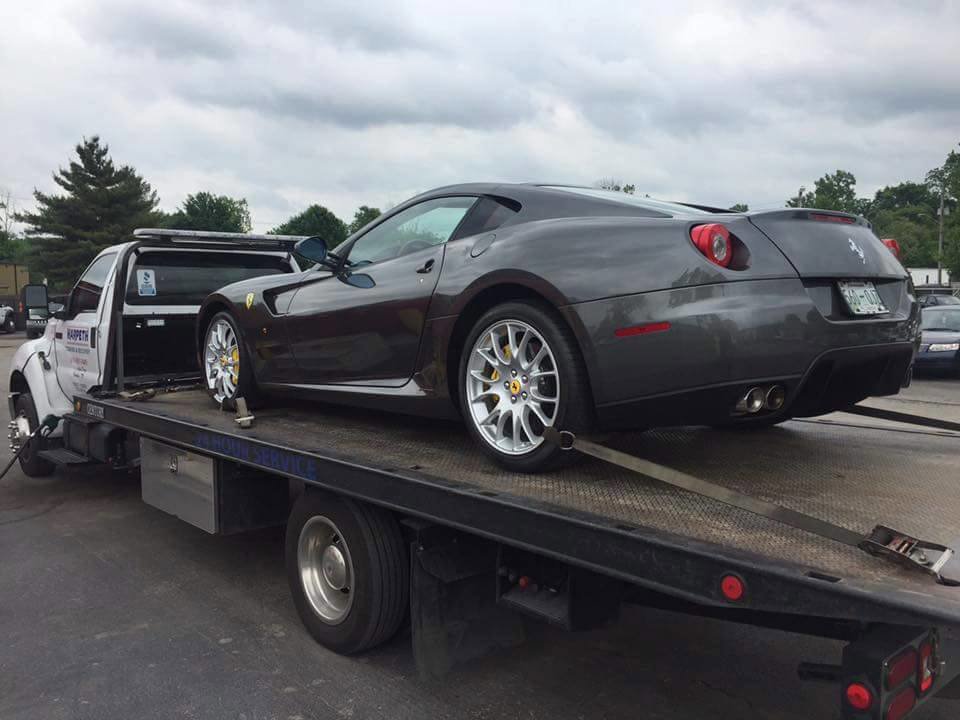 A blue Porsche sports car being transported on a flatbed tow truck by Harpeth Towing & Recovery in Franklin, TN.