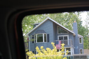 A residential home featuring blue siding and a bay window, completed by Murphy Builders- Genesee County in Ossineke, MI.