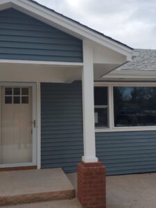 New blue siding installed on the front of a home with a white porch column by River City Exteriors in San Antonio, TX