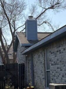 Blue siding installed on a brick chimney of a home by Ideal Siding Dallas, TX.