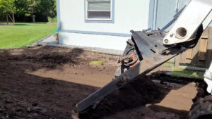 Close-up of a Bobcat attachment grading land during site preparation by ROUGH 2 READY in Auburn, AL