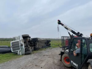 A Bobcat skid steer from Glenn's Towing & Recovery Inc assisting in the recovery of an overturned semi-truck in Lafayette, LA.