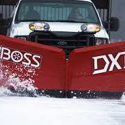 A white truck with a red BOSS DXT snow plow actively pushing snow, demonstrating snow removal by Mr Plow in South Salt Lake, UT.