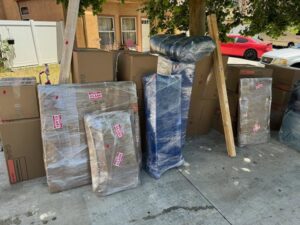 Moving boxes and wrapped items on a sidewalk, ready for loading by Household Goods Moving and Storage in Rockville, MD