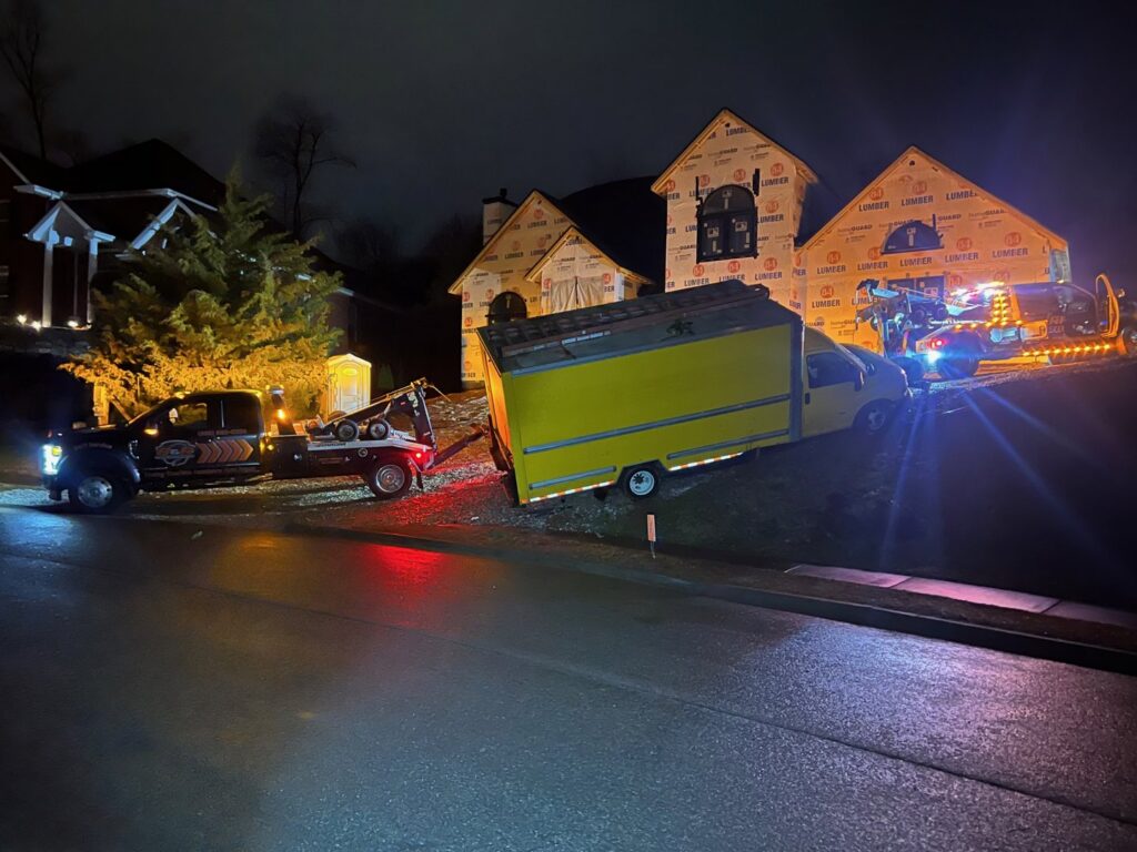 A B&R Towing and Automotive truck recovering a yellow box truck that went off the road at night in Knoxville, TN.