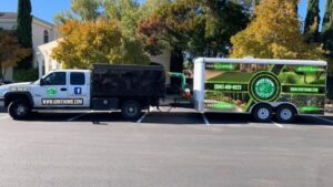 A branded work truck and trailer for Green Thumb Lawn Care & Maintenance, LLC, showcasing their services in Rio Rancho, NM.
