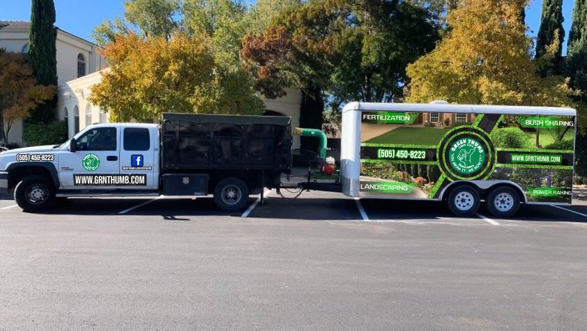 A branded work truck and trailer for Green Thumb Lawn Care & Maintenance, LLC, showcasing their services in Rio Rancho, NM.