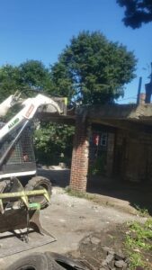 A skid steer from Allied Wrecking Boston demolishing a brick structure in East Boston, MA.