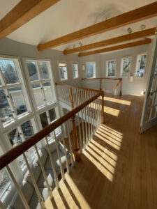 A bright and clean living area with a wooden staircase, maintained by Straight Up Cleaning in South Portland, ME.
