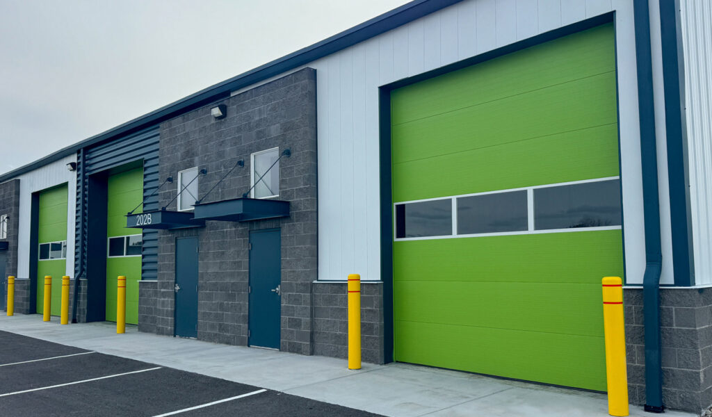 Multiple bright green commercial garage doors installed on a building by Canyon Overhead Doors in Salt Lake City, UT.
