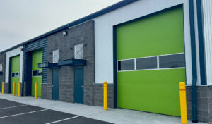 Multiple bright green commercial garage doors installed on a building by Canyon Overhead Doors in Salt Lake City, UT.