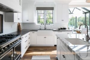 A bright and modern kitchen with white cabinets and dark countertops, showcasing the cleanliness provided by YQP Cleaning Services in Miami, FL.