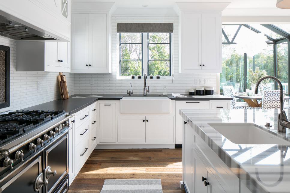 A bright and modern kitchen with white cabinets and dark countertops, showcasing the cleanliness provided by YQP Cleaning Services in Miami, FL.