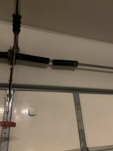 A close-up of a broken garage door torsion spring, indicating a repair job by Cactus Garage Doors, Inc. in North Las Vegas, NV.