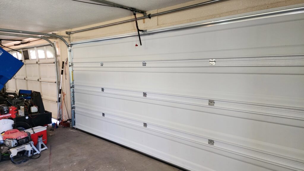 A close-up view of a broken garage door spring, indicating a repair job by Custom Overhead Doors of Southern New Mexico in Alamogordo, NM.