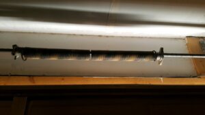 A close-up of a broken garage door torsion spring, indicating a need for repair by Sandia Garage Door Repair in Albuquerque, NM