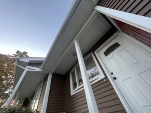 Close-up of newly installed brown horizontal siding with crisp white trim by DL Roofing and Siding in New Haven, CT