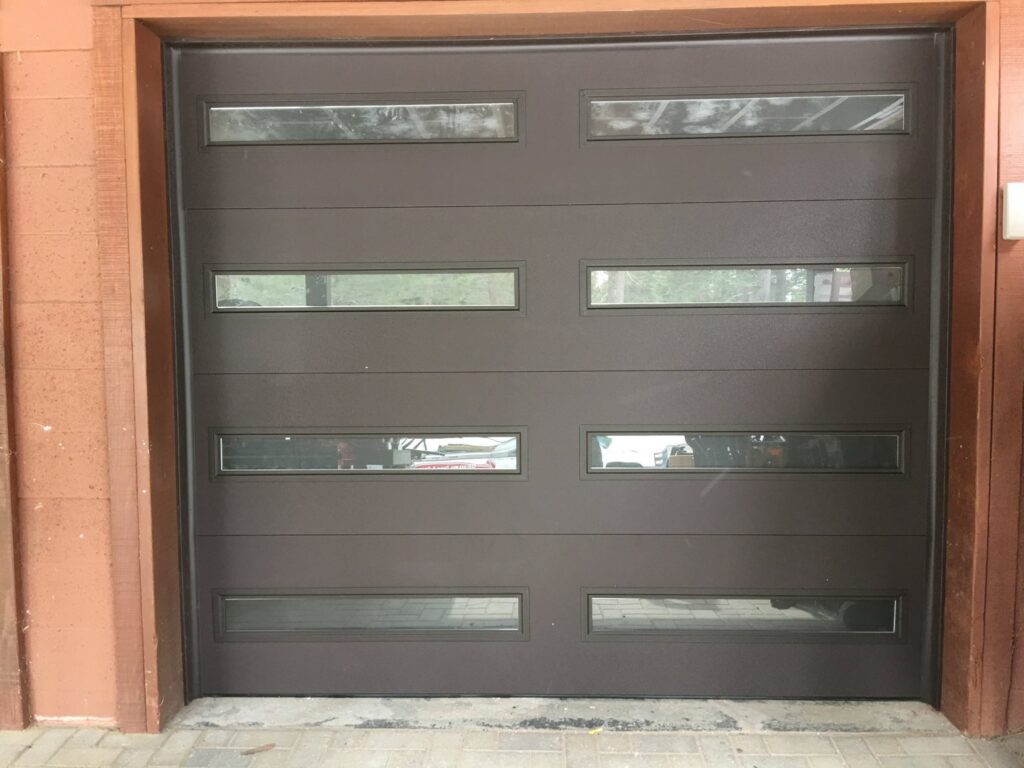 A brown modern garage door with horizontal windows installed by Overhead Door of Sierra Nevada in Reno, NV.