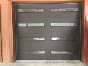 A brown modern garage door with horizontal windows installed by Overhead Door of Sierra Nevada in Reno, NV.