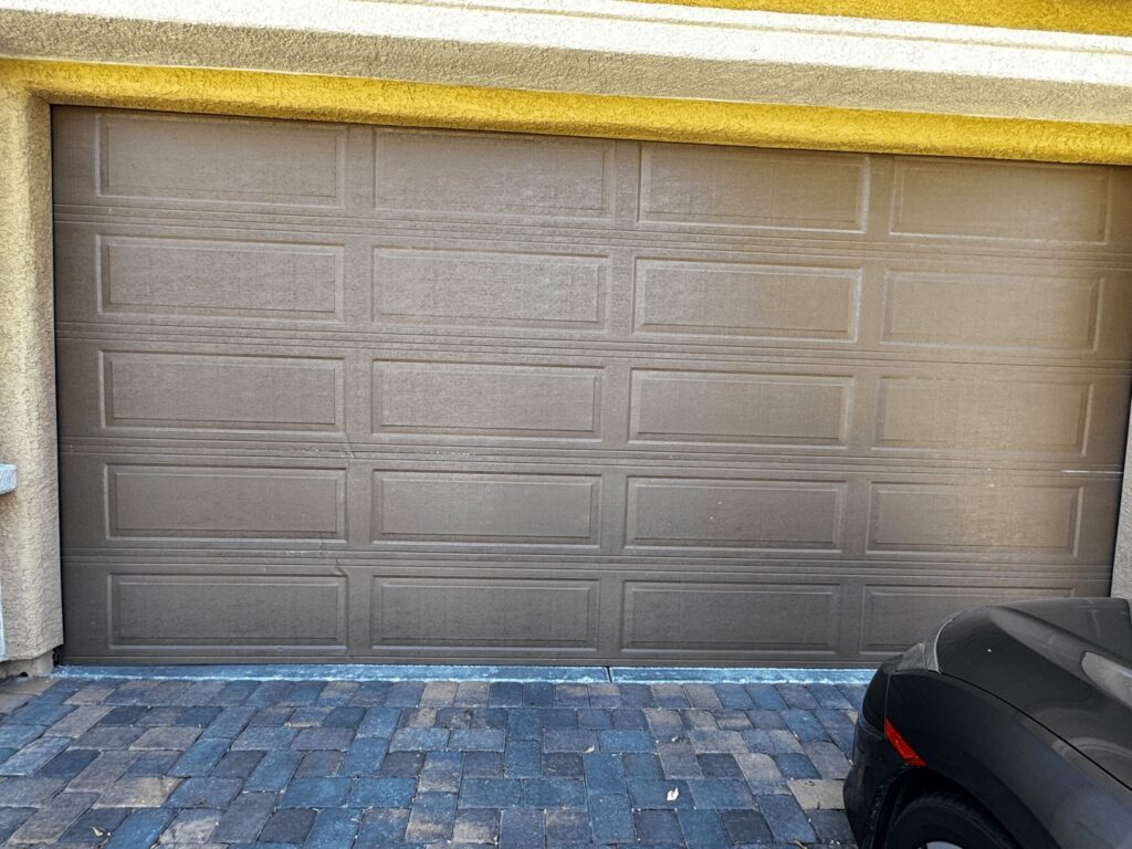 A brown panel garage door installed on a residential home by Apex Garage Doors LLC in Las Vegas, NV
