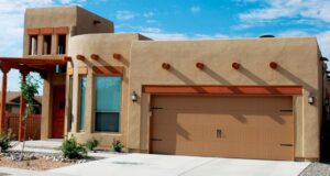 A brown panel garage door with decorative hardware on a southwestern-style home by Mark's Garage Door Services in Santa Fe, NM.