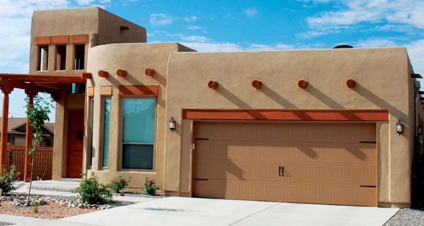 A brown panel garage door with decorative hardware on a southwestern-style home by Mark's Garage Door Services in Santa Fe, NM.