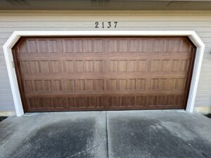 A classic brown panel garage door installed on a residential home by Woodwards Overhead Door Co. in Topeka, KS
