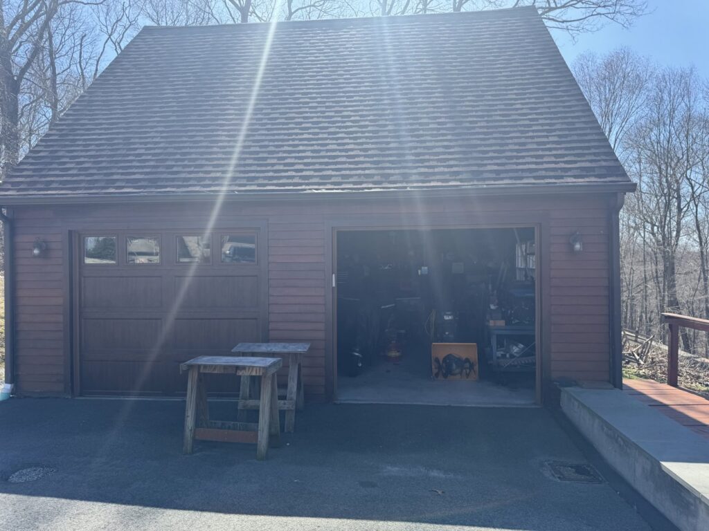 A garage with brown siding and matching garage doors, completed by J&J Rivera Roofing and Supply Co in Old Saybrook, CT