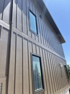 A close-up view of brown vertical siding with contrasting black trim, expertly installed by New Look Siding in Midvale, UT.