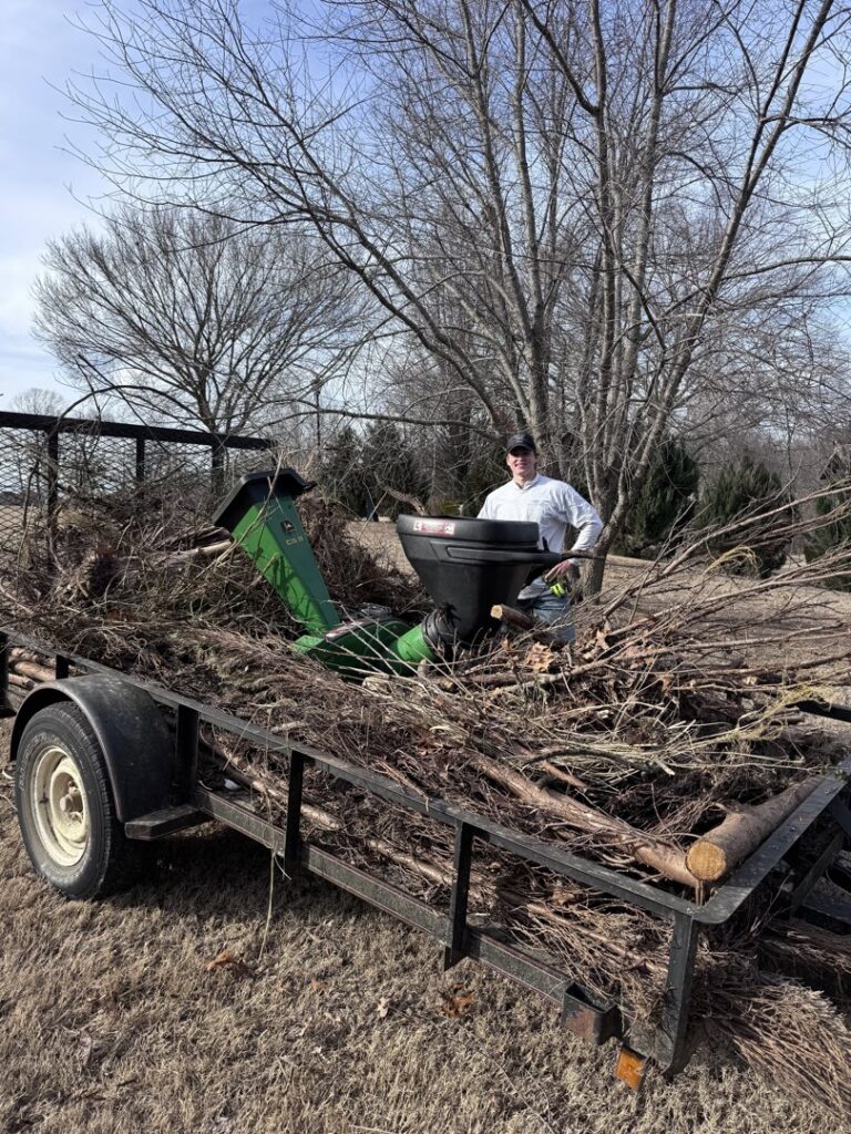 A trailer loaded with brush and debris after a cleanup by All in- Landscaping and Power-washing in Fayetteville, AR.