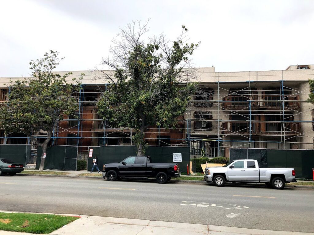 A building demolition site with scaffolding and safety barriers managed by DEMO Leaders in Los Angeles, CA
