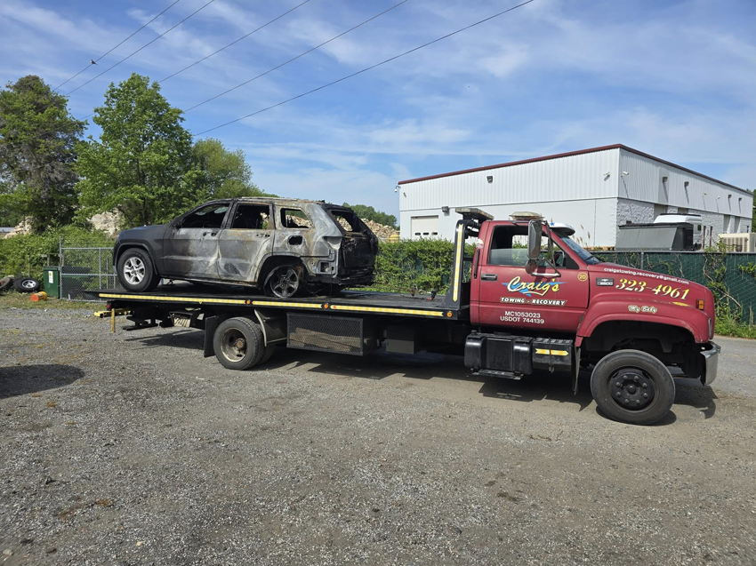 A burned SUV secured on a flatbed tow truck from Craig's Towing & Recovery in New Castle, DE.