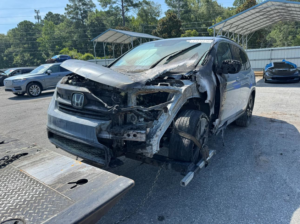 A burnt Honda vehicle being prepared for towing by Southeastern Towing and Transport in Savannah, GA.