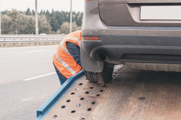 A car being loaded onto a flatbed tow truck by a service person for San Diego Alpha Towing in San Diego, CA