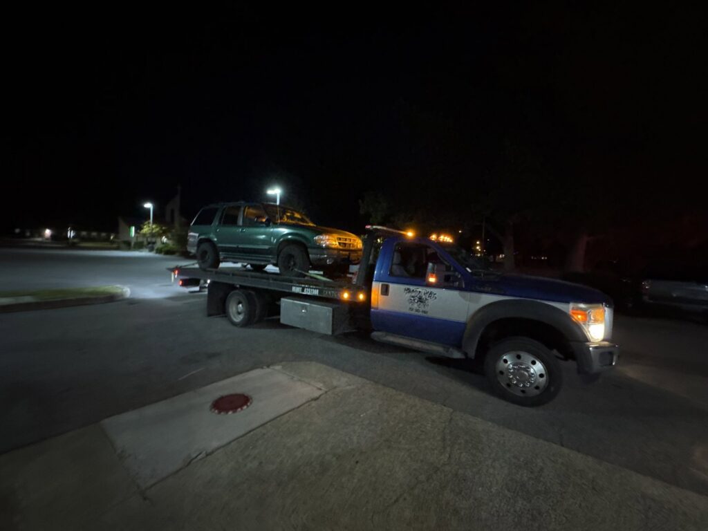 A car being transported on a flatbed tow truck on the highway by Hampton Roads Towing Services in Chesapeake, VA.