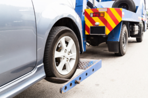 A car being loaded onto a flatbed tow truck by Bobby's TCB Towing in Detroit, MI