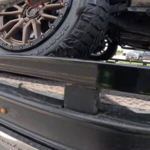 A car tire secured with a wheel chock on a flatbed tow truck, performing a towing service for Fort Benning Towing in Columbus, GA