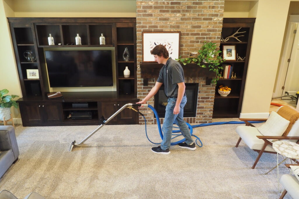 A technician performing carpet cleaning in a living room by Idaho Gem Cleaning in Caldwell, ID.