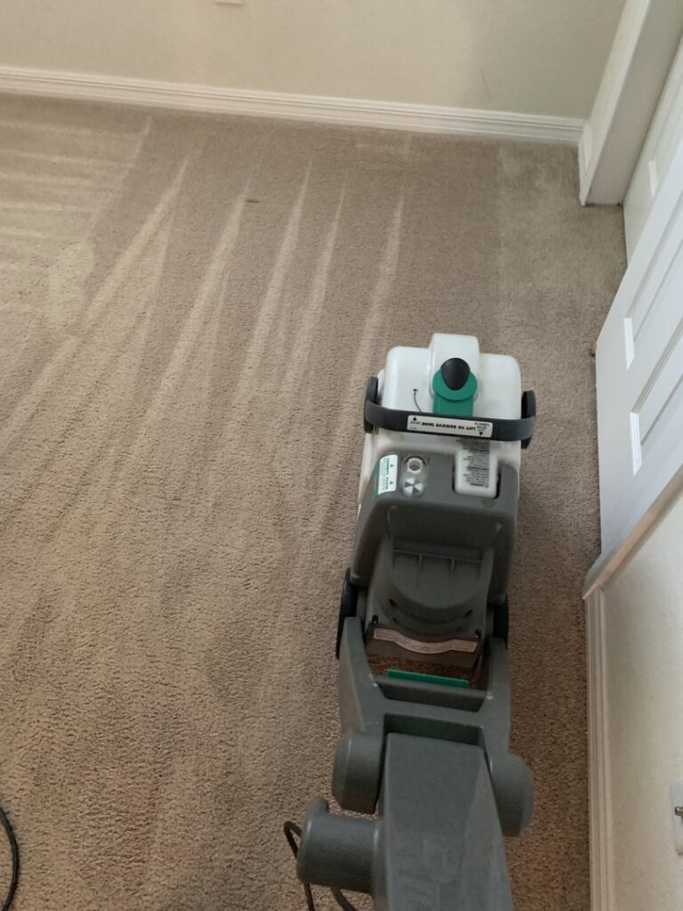 A professional carpet cleaning machine in action, leaving clean lines on a residential carpet by Cleaning Partners in Tampa, FL