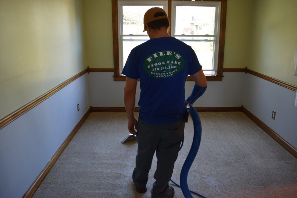 A technician from Pile's Carpet Care & Restoration Service cleaning carpet in a room in Elizabethtown, KY.