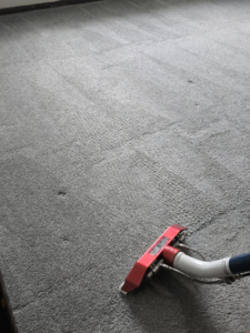 A carpet cleaning tool in action, showing a freshly cleaned grey carpet by Harsh's Cleaning Services LLC in Canton, OH.