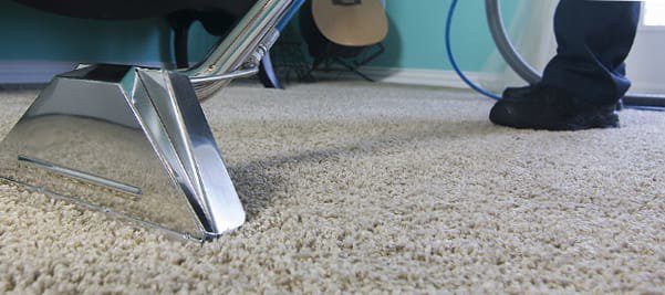 A close-up of a professional carpet cleaning wand in action on a plush carpet by Flawless Home & Business Cleaning LLC in Fargo, ND.