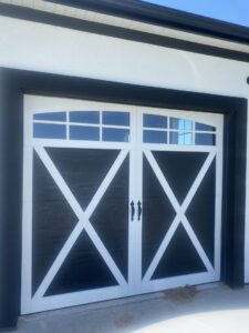 A black and white carriage-style garage door with decorative X-braces and windows installed by Apex Garage Doors in Columbus, OH.