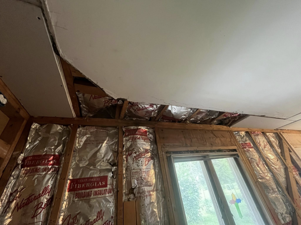 A damaged ceiling with drywall removed, exposing insulation during water damage repair by 24K Restoration in Flint, MI.