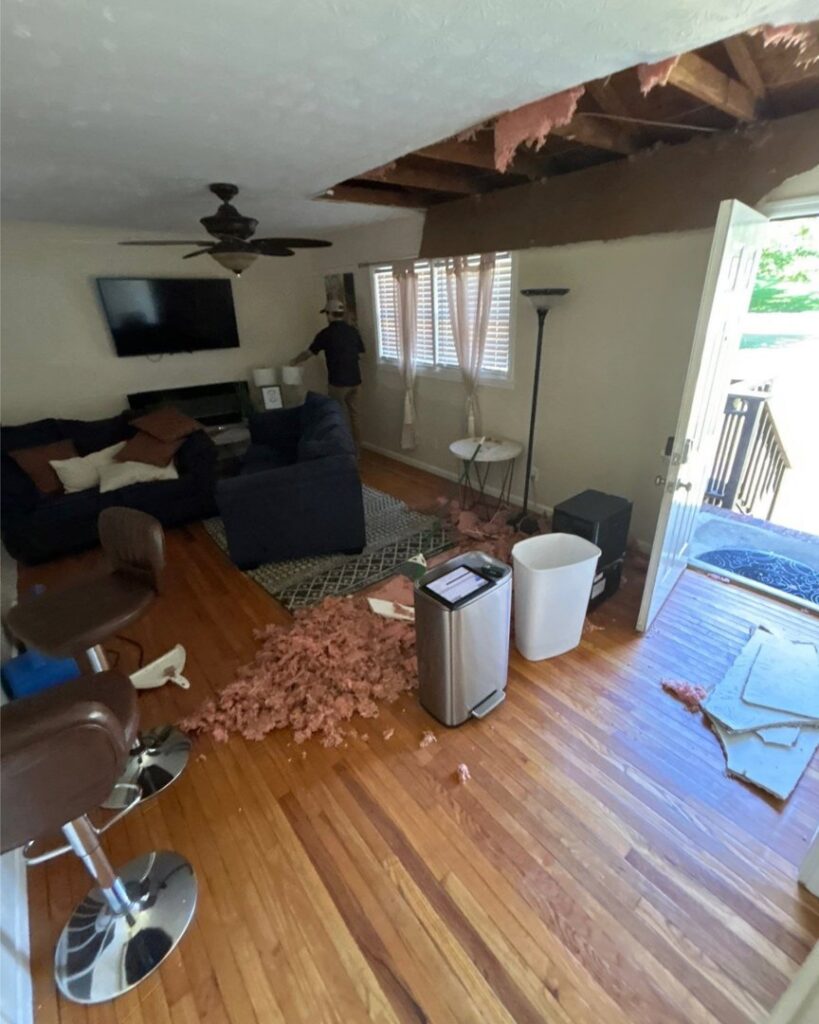 A living room undergoing water damage remediation with a damaged ceiling and insulation removed, performed by Level Creek Property Restoration in Buford, GA.