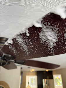 A close-up of a ceiling fan blade covered in cleaning foam by Eco-Terra Clean in Fort Lauderdale, FL.