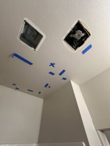 Ceiling with blue tape marking areas for moisture assessment and open vents for drying by The Recover Tech Restoration in Vancouver, WA.